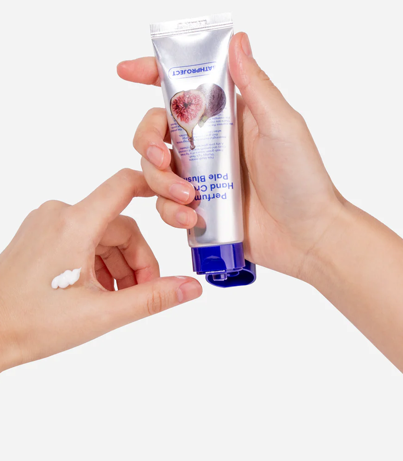 Hand holding a tube of Hand Balm with visible cream on fingers