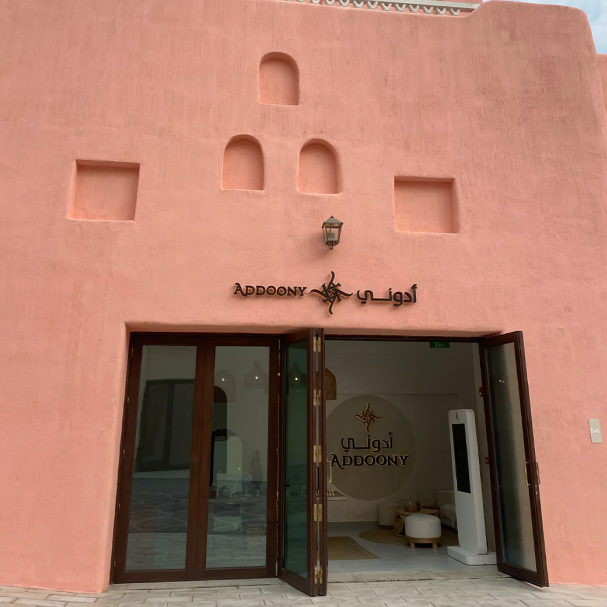 Pink building with 'Addoony' branding and open doors revealing interior.